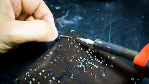 Hands using a soldering iron on a circuit board